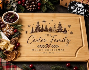 May include: A rectangular bamboo cutting board featuring a laser-engraved winter scene with pine trees, a cabin, and snowflakes. The text reads: The Carter Family, MERRY CHRISTMAS, EST. 2026. The board has a grooved edge for liquid collection.