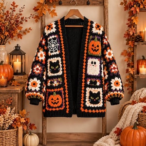 May include: A long-sleeve open-front cardigan made of crocheted granny squares in black, orange, and white. The garment features motifs of jack-o'-lanterns, black cats, a ghost, and a spider web, with floral patterns integrated throughout the design.