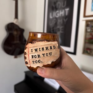May include: A brown ceramic mug with a glossy finish featuring a textured, light-colored rectangular patch that resembles a piece of notebook paper. The patch has black stamped text that reads, I WISHED FOR YOU TOO.