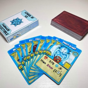 Peut inclure: Un jeu de cartes à collectionner fait par des fans comprenant une boîte marquée School of Ice, une pile de cartes au dos rouge foncé et un éventail de cartes à bordure bleue. La carte de devant montre une illustration de Frost Giant.