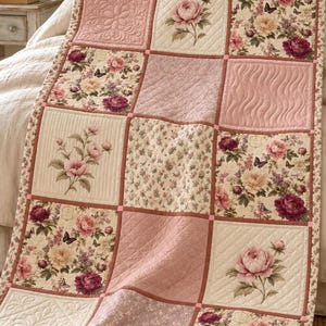 May include: A patchwork quilt featuring a grid of alternating squares. Some squares display floral patterns with peonies, roses, and butterflies in shades of pink, cream, and burgundy. Other squares feature solid pink fabric with quilted textures.