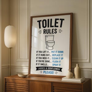 May include: A framed wall art print featuring the text TOILET RULES in black, a central illustration of a white toilet, and a list of instructions in black and blue text including IF YOU LIFT IT... PUT IT DOWN and LADIES & GENTLEMEN PLEASE!