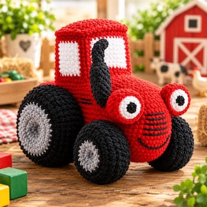May include: A red crochet tractor toy featuring a black exhaust pipe, white windows, and large black wheels with grey centres. The tractor has two round white eyes with black pupils and a stitched black smile on the front grill area.