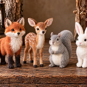 May include: A set of four needle-felted animal figurines including a red fox with a white-tipped tail, a brown fawn with white spots, a grey squirrel with a bushy tail, and a white rabbit with pink-tinted ears, all standing in a row.