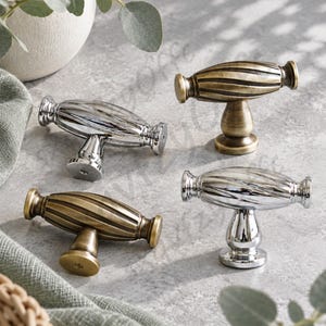 May include: Four T-shaped cabinet knobs arranged in a group. Two knobs feature a polished chrome finish, while the other two have an antique brass finish. Each knob has a central horizontal bar with a ribbed, spiraled texture and a round base.