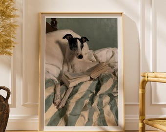 Puede incluir: Una lámina de arte enmarcada que representa a un perro blanco y negro descansando sobre una cama con almohadas blancas y una manta de rayas azules y blancas. El perro está detrás de un libro abierto, con la cabeza levantada hacia el espectador.