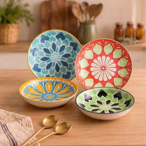 May include: A set of four ceramic bowls featuring vibrant, multi-colored mandala-inspired patterns. Two bowls are upright, displaying intricate floral designs in shades of blue, red, green, and yellow, while two bowls sit flat with matching patterns.