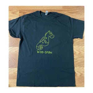 Pode incluir: Camiseta preta com um desenho de linha verde de um cavalo-marinho e o texto "Wee-snaw" abaixo.