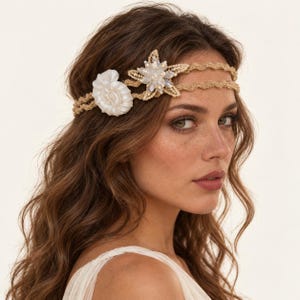 May include: A double-strand tan crochet headband featuring a white spiral seashell and a star-shaped embellishment made of clear, iridescent crystals and gold-toned thread, worn across the forehead with a wavy, textured appearance.