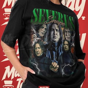Puede incluir: Una camiseta negra de manga corta con un estampado gráfico de Severus Snape en varias poses. El diseño incluye el texto "SEVERUS" en letras verdes grandes y "Snape" en letra cursiva, acentuado con rayos blancos sobre un fondo oscuro.