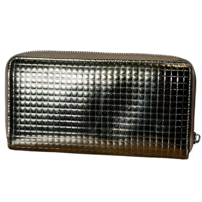 May include: A metallic silver wallet with a textured, grid-like pattern. The rectangular wallet has a zipper closure and a small silver pull. The overall design is sleek and modern, suitable for carrying essentials.
