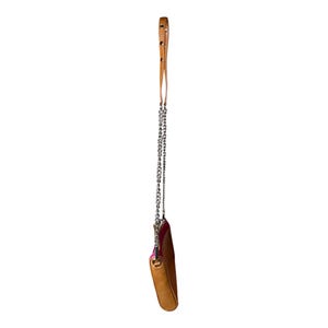 Puede incluir: Un peque&ntilde;o bolso bandolera de cuero marr&oacute;n claro con una correa de cadena plateada y un asa de cuero marr&oacute;n claro a juego. El bolso tiene un interior rosa y est&aacute; suspendido sobre un fondo blanco.