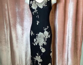 Vestido largo vintage Y2K con pétalos susurrantes, etéreo y atemporal, con fondo oscuro.