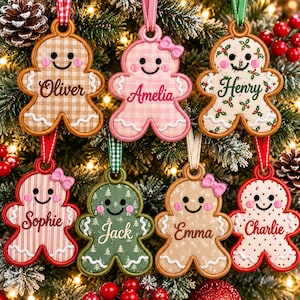 May include: Seven gingerbread-shaped fabric ornaments with embroidered faces and names. The ornaments feature various patterns including gingham, holly, stripes, and dots, each topped with a ribbon loop and some with small fabric bows.