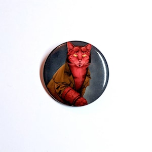 May include: A red cat with yellow eyes wearing a brown leather jacket with a red arm. The cat is on a dark grey background.