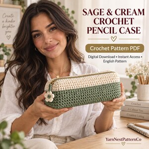 Può includere: Un astuccio rettangolare all'uncinetto caratterizzato da un design bicolore con una base verde salvia e una parte superiore color crema. L'astuccio include una chiusura a zip dorata con un piccolo ciondolo a forma di fiore.