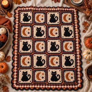 May include: A rectangular crochet blanket featuring a repeating pattern of black cats and orange crescent moons with small stars on a cream background. The blanket has a scalloped border in dark brown, orange, and cream yarn colors.