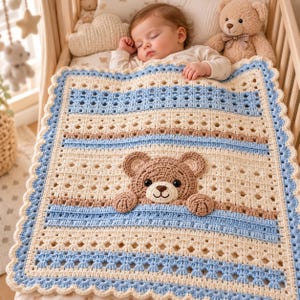 Puede incluir: Una manta de bebé tejida a ganchillo de forma cuadrada con una paleta de colores crema, azul claro y beige. La manta presenta un intrincado patrón calado y un borde festoneado. Un oso de peluche tejido en relieve está centrado.