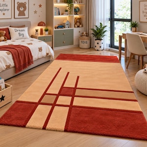Puede incluir: Una alfombra rectangular con un patrón geométrico de líneas que se cruzan y bloques sólidos en tonos rojo intenso, bronceado y beige. El diseño consta de un borde rojo grande en un extremo y una serie de líneas horizontales y verticales.