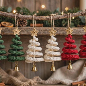 May include: Six spiral-shaped Christmas tree ornaments made of crocheted yarn in green, cream, and red. Each ornament features a small crocheted star at the top, a jute hanging loop, and a metallic gold bell attached to the bottom point.