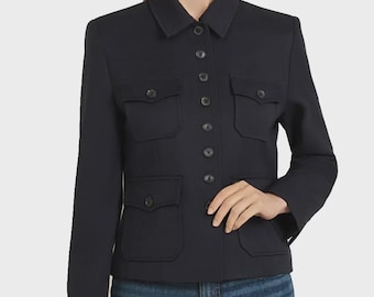 Peut inclure: Une veste bleu marine foncé dotée d'un col structuré, d'une fermeture boutonnée sur le devant et de quatre poches plaquées symétriques avec des rabats boutonnés. La veste a des manches longues et est portée sur un jean bleu.
