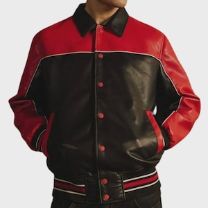 Puede incluir: Una chaqueta estilo universitario de bloques de color con cuerpo negro y mangas rojas. La prenda cuenta con cuello negro, cierre frontal de botones rojos y ribetes acanalados a rayas en negro, rojo y blanco en los puños y el dobladillo.