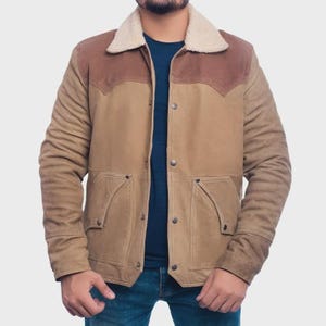 May include: A tan and brown jacket featuring a cream-colored faux shearling collar, a button-front closure with metal snaps, and two large front pockets with diagonal openings. The garment has a two-tone design with darker brown shoulder yokes.