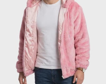 May include: A light pink faux fur zip-up hoodie featuring a smooth, matching satin lining. The jacket is worn over a plain white t-shirt and dark blue denim jeans, showcasing a full-length front zipper and a soft, textured exterior.