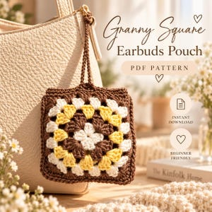 Könnte beinhalten: Eine quadratische Häkeltasche mit Granny-Square-Muster aus braunem, gelbem und weißem Garn. Die Tasche hat einen braunen Häkelriemen und ist an einer cremefarbenen Tasche befestigt. Der Text auf dem Bild lautet Granny Square Earbuds Pouch PDF PATTERN.