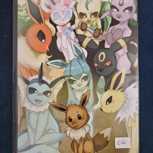 May include: A rectangular art print featuring a group of nine colourful cartoon creatures, including Eevee and its various evolutions. The characters are arranged in a cluster with diverse features like large ears, tails, and distinct colour palettes. A small white sticker with the text £10 is visible in the bottom right corner.