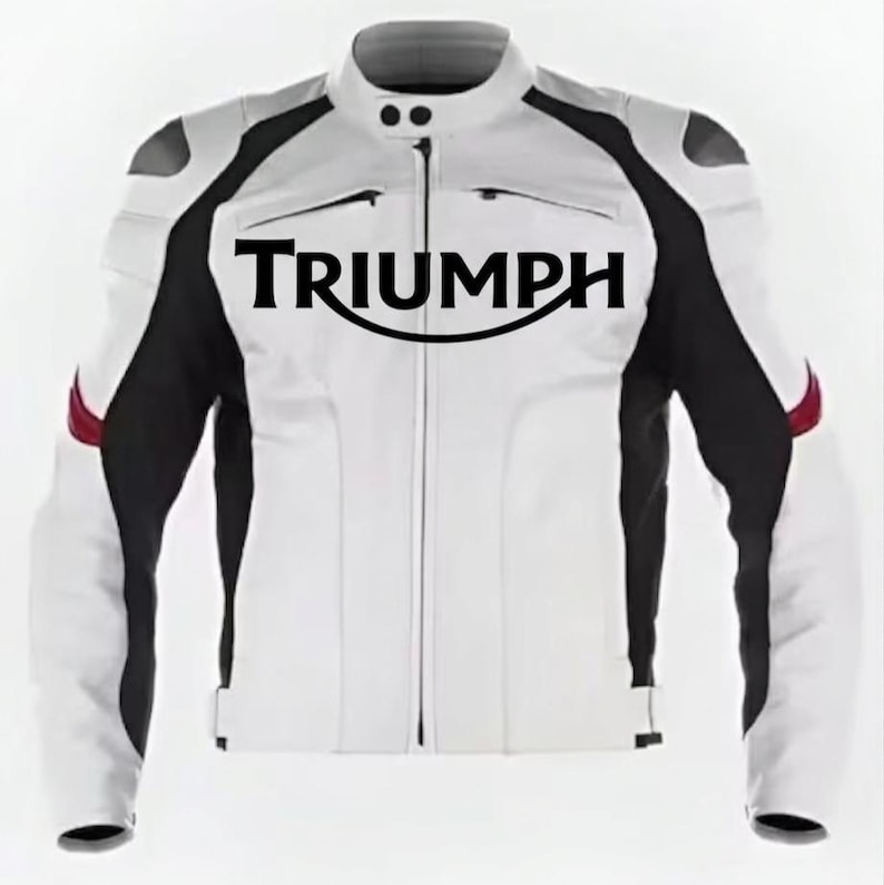 May include: A white and black motorcycle jacket featuring the word TRIUMPH in large black lettering across the chest. The jacket has a mandarin collar with two snap buttons, long sleeves with red accents, and a full-length central zipper closure.