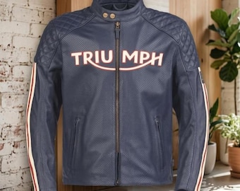 May include: A navy blue perforated leather motorcycle jacket featuring the word TRIUMPH in white and red lettering across the chest. The jacket includes a mandarin collar with two snap buttons, quilted shoulder panels, and vertical side stripes.