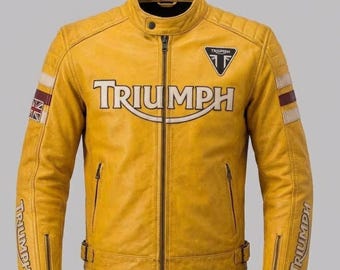 May include: A mustard yellow leather jacket featuring a central zipper, a snap-button collar, and the word TRIUMPH in large lettering across the chest. The sleeves include striped accents, a Union Jack patch, and zippered cuffs with branding.