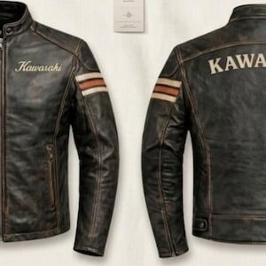 Può includere: Una giacca da moto in pelle marrone scuro dall'aspetto vissuto con colletto alla coreana, chiusura frontale con zip e due tasche laterali con cerniera. Il petto riporta la scritta Kawasaki, mentre sul retro appare il testo KAWASAKI.