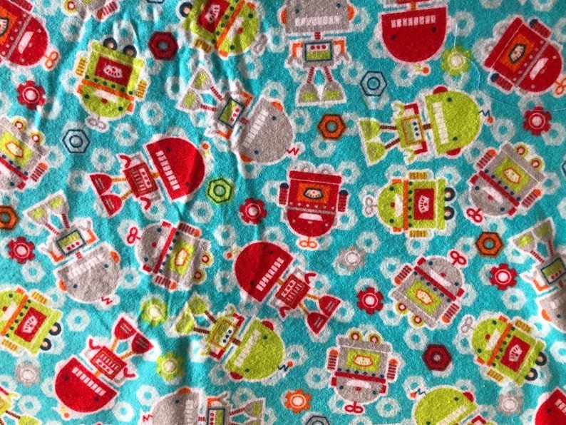 K&ouml;nnte beinhalten: Ein t&uuml;rkisfarbener Stoff mit einem sich wiederholenden Muster aus bunten Robotern. Die Roboter sind rot, gr&uuml;n, grau und orange, mit Details wie Antennen und Zahnr&auml;dern. Der Hintergrund umfasst wei&szlig;e Kreise, rote Blumen und graue Sechsecke.