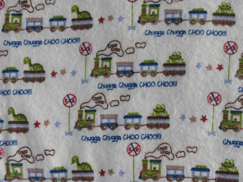 K&ouml;nnte beinhalten: Wei&szlig;er Stoff mit einem sich wiederholenden Muster aus gr&uuml;nen Z&uuml;gen, blauen Waggons und Tierfiguren. Der Text "Chugga Chugga CHOO CHOO!!!" ist in Blau geschrieben. Rote und blaue Sterne und Stoppschilder sind ebenfalls vorhanden.