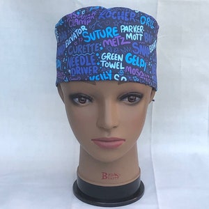 May include: A blue and purple surgical scrub hat with a variety of medical terms printed on it, including "Suture", "Parker", "Metz", "Mott", "Green Gel", "Driver", "Towel", and "Mosquito".