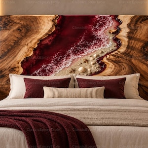 Puede incluir: Un cabecero rectangular con bordes de veta de madera natural y una incrustación central de resina que representa una ola oceánica de color rojo intenso rompiendo en una playa de arena con conchas y estrellas de mar dispersas.