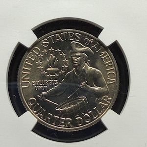 May include: A United States quarter dollar coin featuring a colonial drummer in a tricorn hat playing a drum. The text UNITED STATES OF AMERICA, QUARTER DOLLAR, and E PLURIBUS UNUM are visible, along with a torch surrounded by thirteen stars.