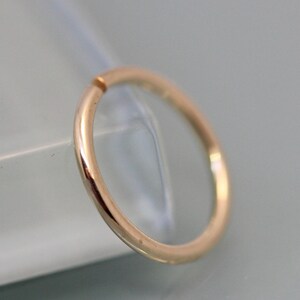 May include: A gold-colored seamless hoop ring, a type of body jewelry.