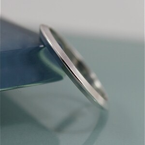 May include: A plain silver wedding band with a smooth, polished finish.