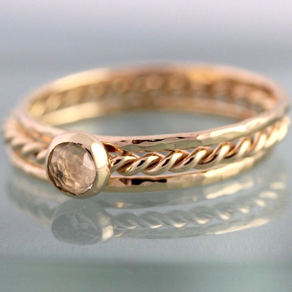 Conjunto de anillos apilables de oro de 14k, con bandas de topacio blanco y diseño de cuerda trenzada.