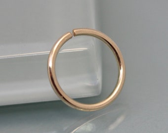 May include: A gold-colored seamless hoop earring. The hoop is made of metal and has a smooth, polished finish.