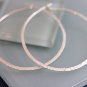 May include: A pair of silver hoop earrings with a textured finish.