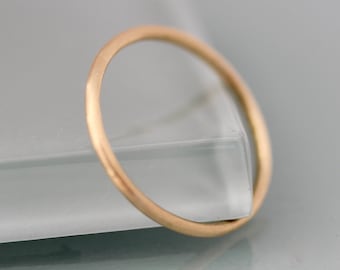 Może przedstawiać: Prosty złoty pierścionek, klasyczny i minimalistyczny design.