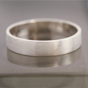 May include: A simple silver wedding band with a brushed finish.