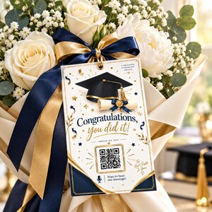 May include: A bouquet of white roses and baby's breath wrapped in cream paper with navy and gold ribbons. A rectangular graduation card hangs from the ribbon, featuring a black mortarboard, a diploma, and a QR code with the text Congratulations, you did it!