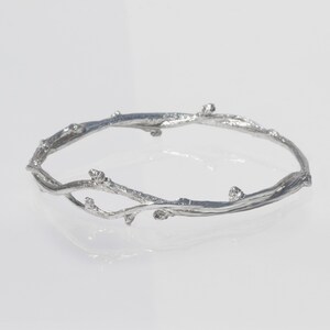 Sterling Silver Twig bangle bracelet Wild Bittersweet Vine.

Wild bittersweet vine is picked in the springtime and woven into a bangle and cast in sterling silver. It retains all of the budding characteristics of the vine.