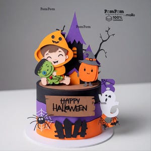 Op de afbeelding: Een meerlaagse papieren taarttopper met een cartoonkind in een oranje capuchon die een groen monster vasthoudt, een paars spookhuis, een pompoen met een heksenhoed, een wit spook, een spin en een bordje met de tekst Happy Halloween in zwart.