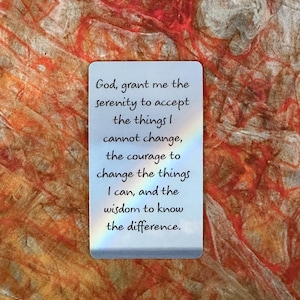 May include: A rectangular card with rounded corners displays the text "God, grant me the serenity to accept the things I cannot change, the courage to change the things I can, and the wisdom to know the difference." The card has a rainbow-like effect and is set against a textured, orange and brown background.